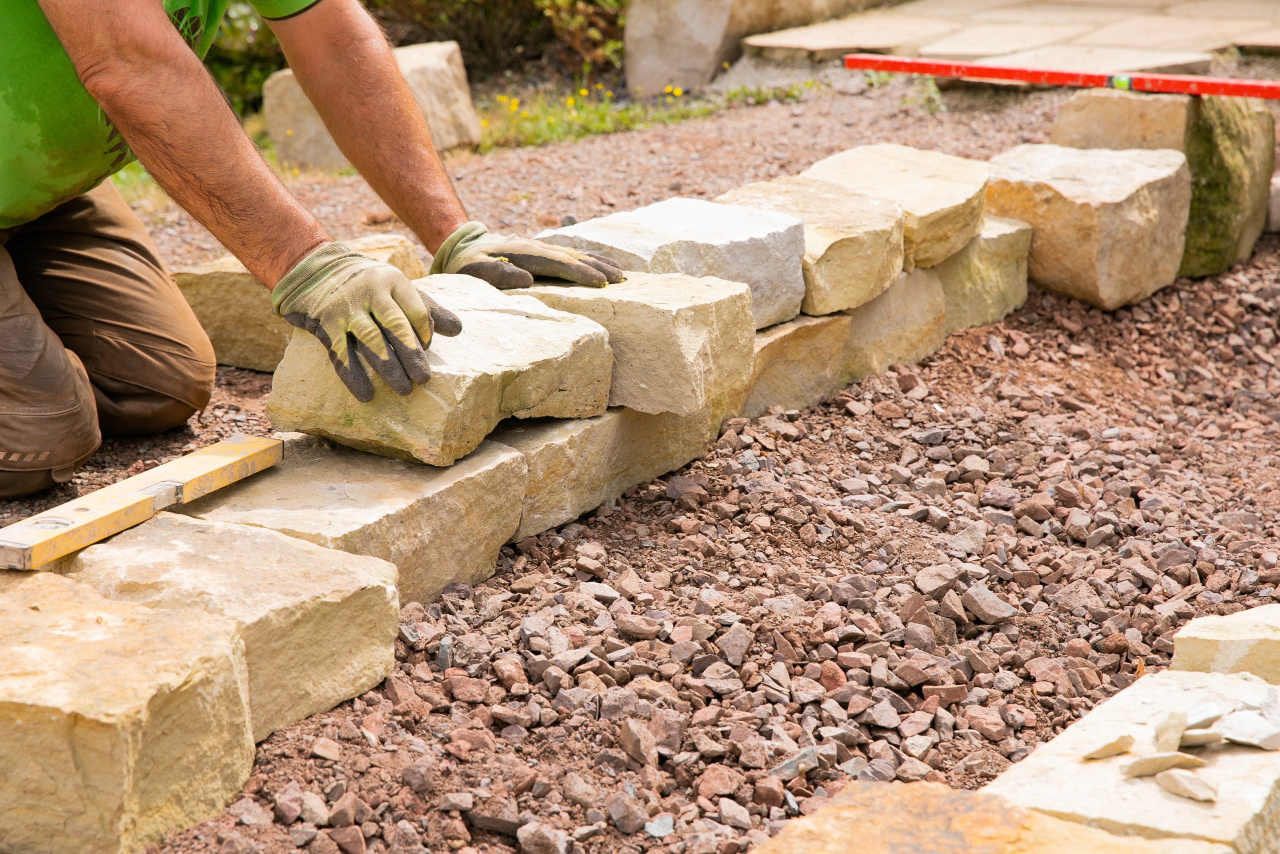 Man landscaping with natural stones –  Building of a dry stone w